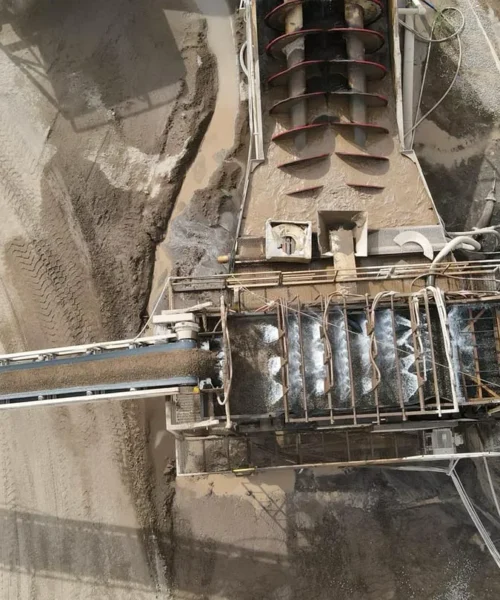An overhead view of a material washing machine, with aggregate conveyors branching off all sides.